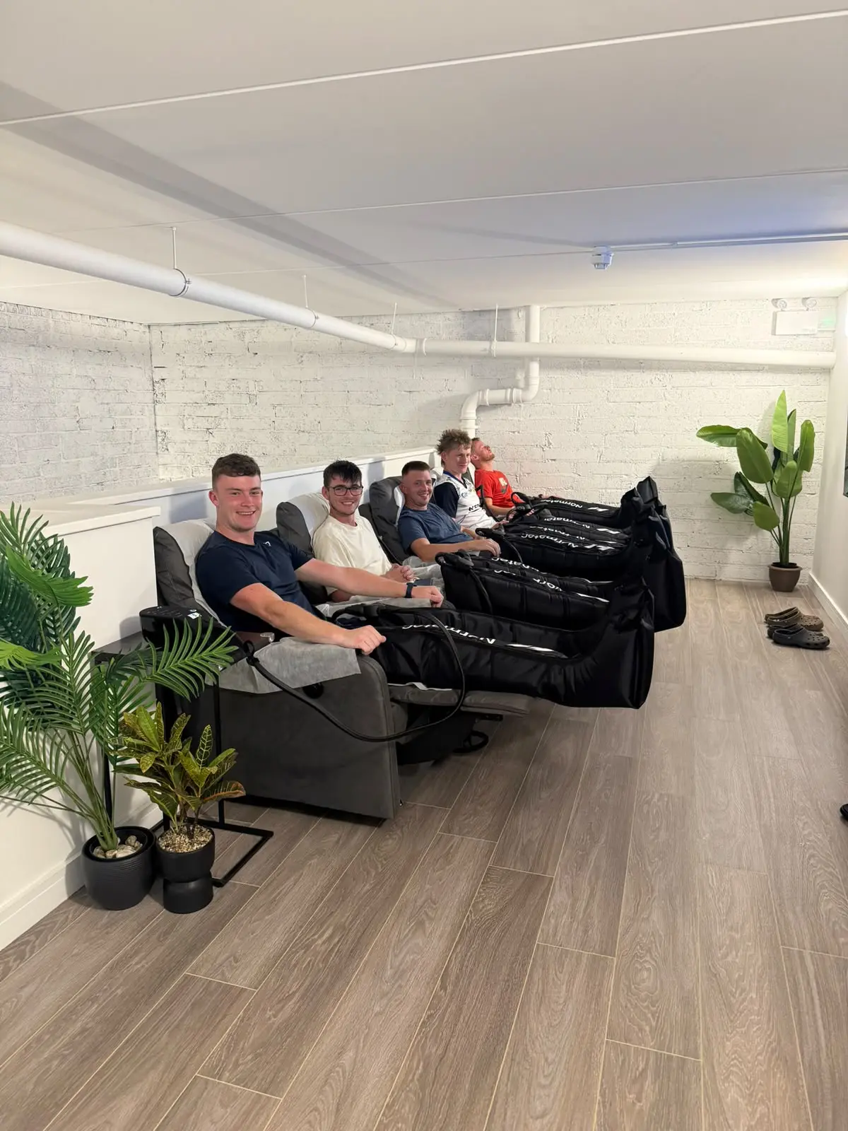 Four guests in the recliners with the boots inflated, palms at the end of the row